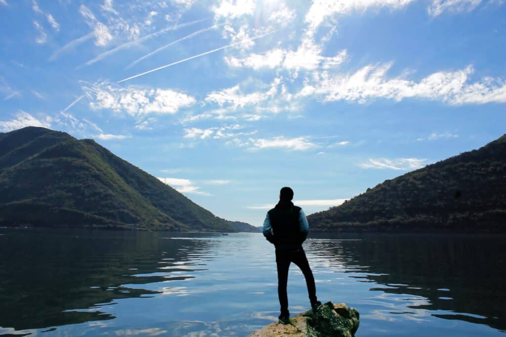 Bild zeigt eine Person vor einem See. Stellvertretend soll diese mentale Gesundheit darstellen.